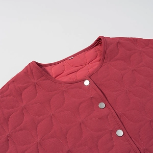 Detail of dark red quilted jacket showing floral stitching and silver metal buttons