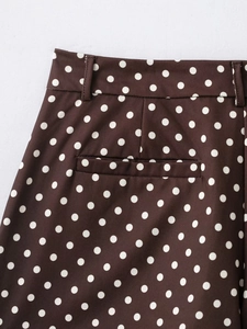 Détail d'un mini-short marron foncé à pois blancs avec passants de ceinture et poche arrière
