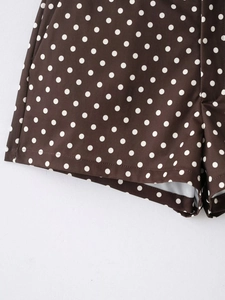 Gros plan du tissu marron à pois et détails de couture sur ce mini short décontracté