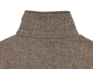 Close-up of stand collar and brown herringbone wool texture on a bomber jacket