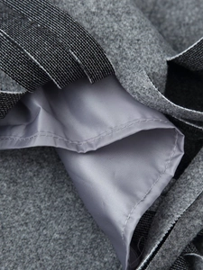 Detailed close-up showing the grey wool fabric and smooth lilac satin lining with neat stitching
