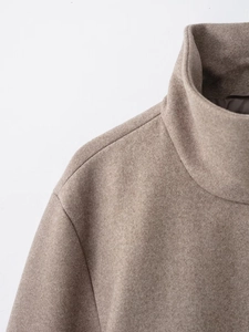 Gros plan d'un manteau en laine camel avec col montant et coutures d'épaule de haute qualité