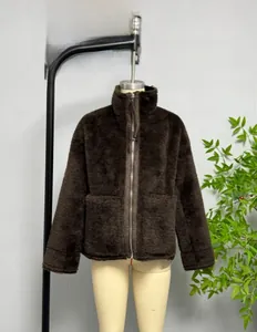 Detail of dark brown faux fur jacket featuring a high collar and metal zipper pocket