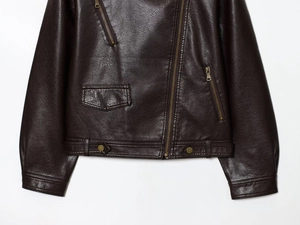 Detail of dark brown PU leather jacket featuring asymmetric zipper and metal hem buckles