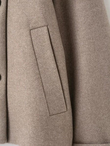Vue détaillée de la veste en laine camel montrant les coutures de poche de haute qualité