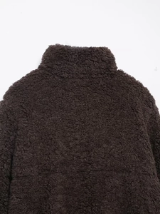 Detailansicht der dunkelbraunen Lammfelljacke mit Stehkragen und dicker Wolltextur