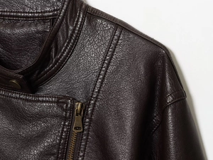 Detail of dark brown PU bomber jacket showing vintage bronze zipper and metallic snap button