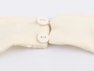 Macro view of beige knit dress back with delicate double button and elastic loop closure