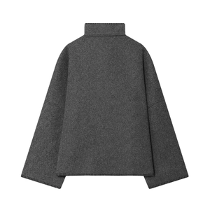 Makrodetail eines dunkelgrauen Wollmischpullovers mit hohem Kragen und sauberer Naht