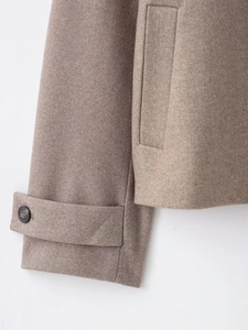 Détail du poignet à bride et de la poche passepoilée d'une veste en laine camel