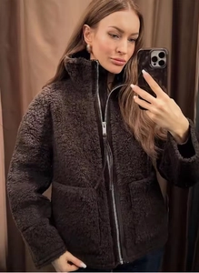 Detail of dark brown sherpa coat with high stand collar and metallic silver zipper