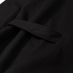 Makroaufnahme der präzisen Nähte und des schwarzen Wollstoffes am Taillengürtel-Detail
