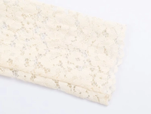 Close-up of elegant floral lace texture and intricate hollow crochet detail on sleeve edge