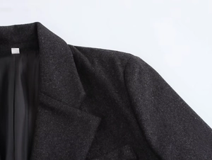 Detail of dark grey wool blazer lapel and shoulder with smooth black lining