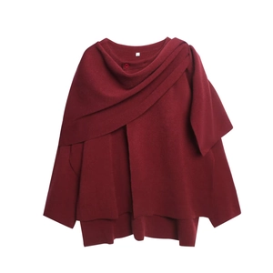 Details von weinrotem Strickponcho-Oberteil mit Wasserfallkragen und passendem Knopfverschluss