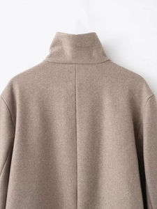Détail du col montant et de la couture d'épaule d'un manteau en laine de couleur camel