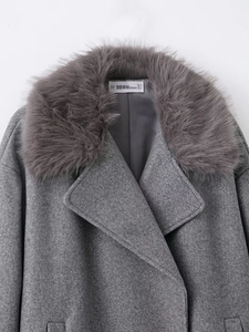 Close-up of a dark grey wool coat featuring a soft faux fur collar and designer label