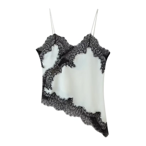 Detailed view of white silk camisole featuring intricate black floral lace and thin straps