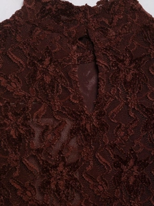 Detailed close-up of dark red floral lace texture and intricate cutout on the midi dress