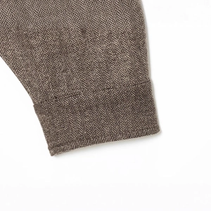 Herringbone pattern texture detail on brown wool blend bomber jacket sleeve