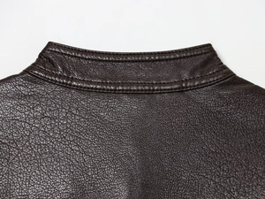 Close-up of brown PU leather jacket featuring lychee texture and double stitching