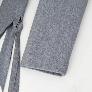 Gray double-breasted wool coat featuring decorative tassels and smooth fabric texture