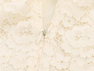 Macro view of ivory lace dress featuring a floral pattern and hidden back zipper
