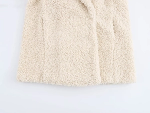 Detail of cream teddy fleece texture and side seam on a cozy faux fur coat for women