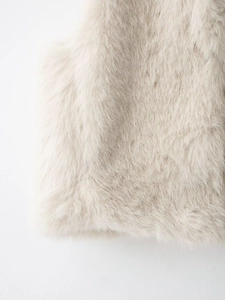 Détail d'un gilet en fausse fourrure crème montrant la texture moelleuse et synthétique