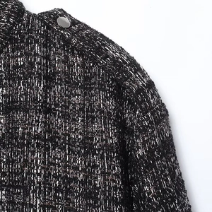 Macro shot of tweed texture with metallic silver threads and polished silver shoulder button