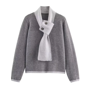 Détail du pull en maille avec col écharpe à côtes épaisses et bouton décoratif