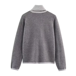 Détail du pull en tricot gris foncé avec col et poignets côtelés de couleur blanc cassé