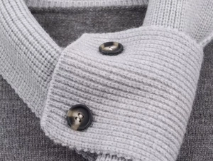 Détail du col en tricot gris avec texture côtelée et boutons en écaille de tortue foncée