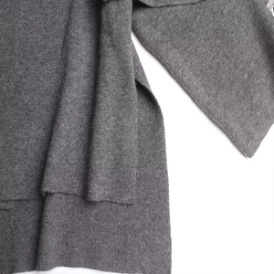 Detailaufnahme der Seitennaht und engen Strickstruktur bei diesem dunkelgrauen Strickpullover