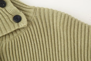 Close-up of olive green ribbed knit texture and vintage brown buttons on a sweater