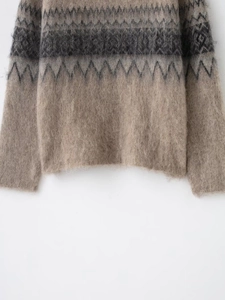 Close-up detail of earthy beige knit sweater with grey Fair Isle geometric jacquard pattern