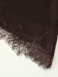 Detail of dark brown satin fabric with delicate eyelash lace trim and refined texture