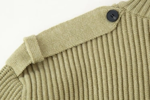 Close-up of sage green ribbed knit sweater with decorative shoulder strap and black button