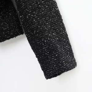 Detailed close-up showing the premium black and white tweed fabric texture and weave