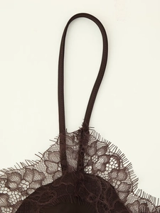 Detailed macro view of dark brown eyelash lace fabric and thin straps on camisole top