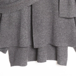Detail der dunkelgrauen Strickwaren mit asymmetrischem Schichtsaum und Strukturstoff