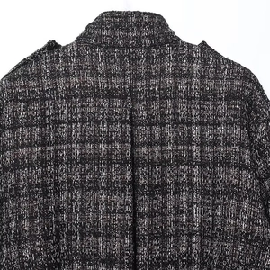 Detailed macro view of black and white tweed fabric texture on a bomber jacket collar