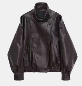 Close-up of vintage brown biker jacket showing lychee grain texture and snap collar