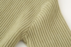 Close-up of fine ribbed knit shoulder seam on a sage green turtleneck sweater cardigan