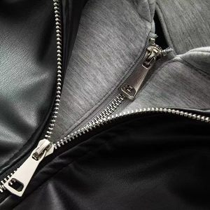 Détail macro d'une veste en simili cuir avec double zip et doublure en maille grise