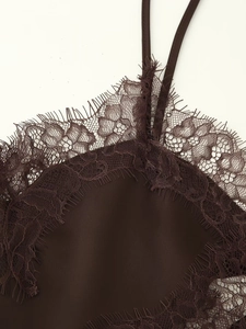 Close-up of deep brown satin top featuring delicate eyelash lace trim and thin straps