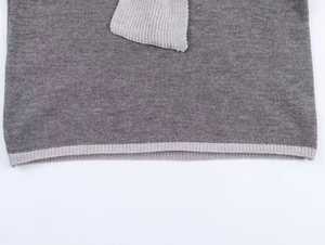 Détail de la bordure contrastée et de la texture en maille de qualité de l'ensemble gris