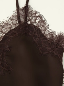 Detail of dark brown satin camisole featuring delicate eyelash lace trim and fine straps