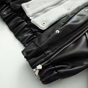 Détail de la veste en maille grise et similicuir noir avec fermeture éclair métallique
