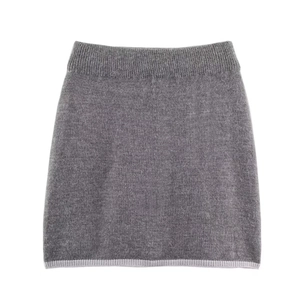Détail d'une jupe en maille gris foncé avec bordure contrastée et taille élastique souple